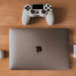 A picture of a laptop and a playstation 4 controller